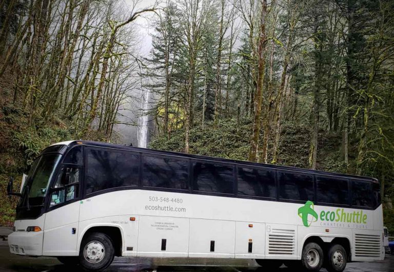 Pacific Northwest Charter Bus parked at a waterfall.