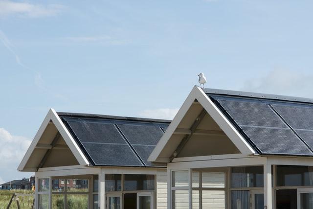 Roofs of two homes with solar panels installed on them.