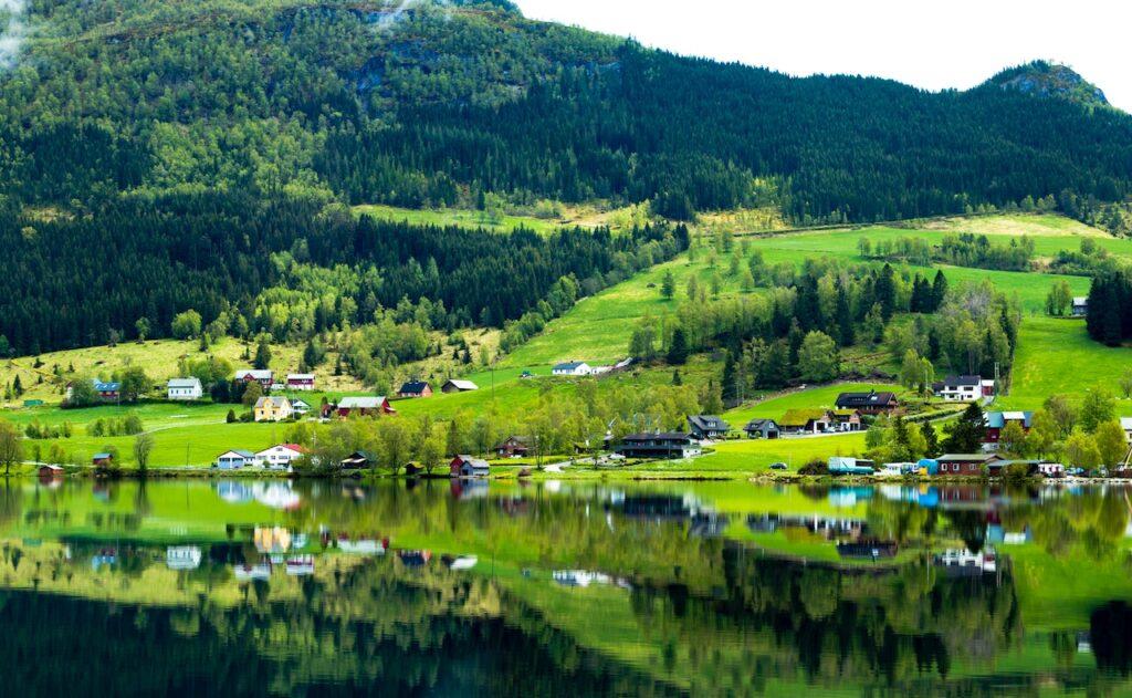 A village in Norway next to a lake.