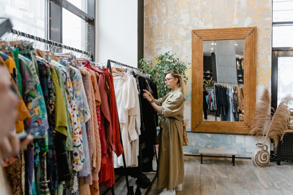 a woman shopping for sustainable clothes in order to support the circular economy. 