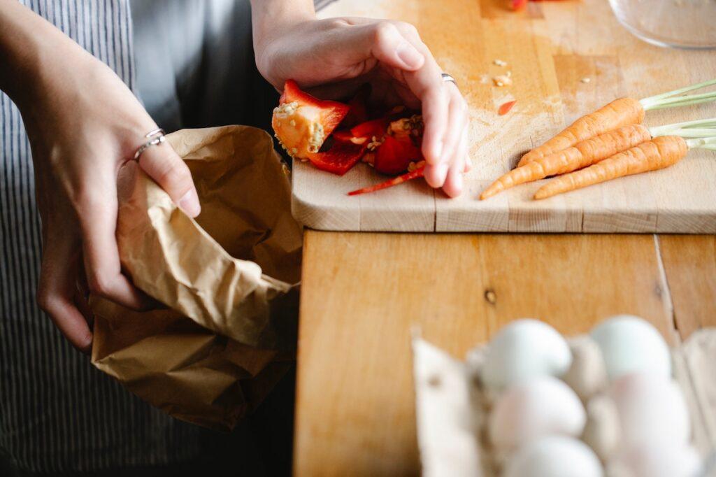 A person putting leftover food into a bag.