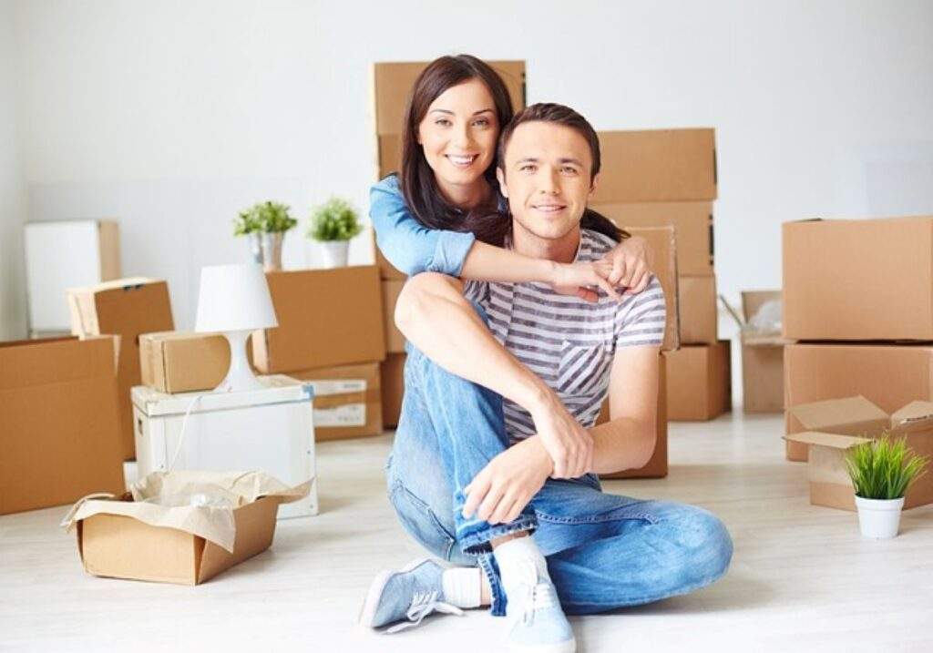  A couple surrounded by boxes preparing for a move.
