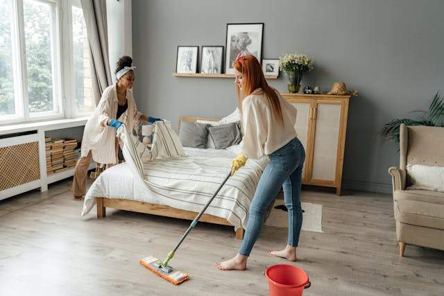 Women cleaning a bedroom using green cleaning tips ensure a healthier, eco-friendly environment.