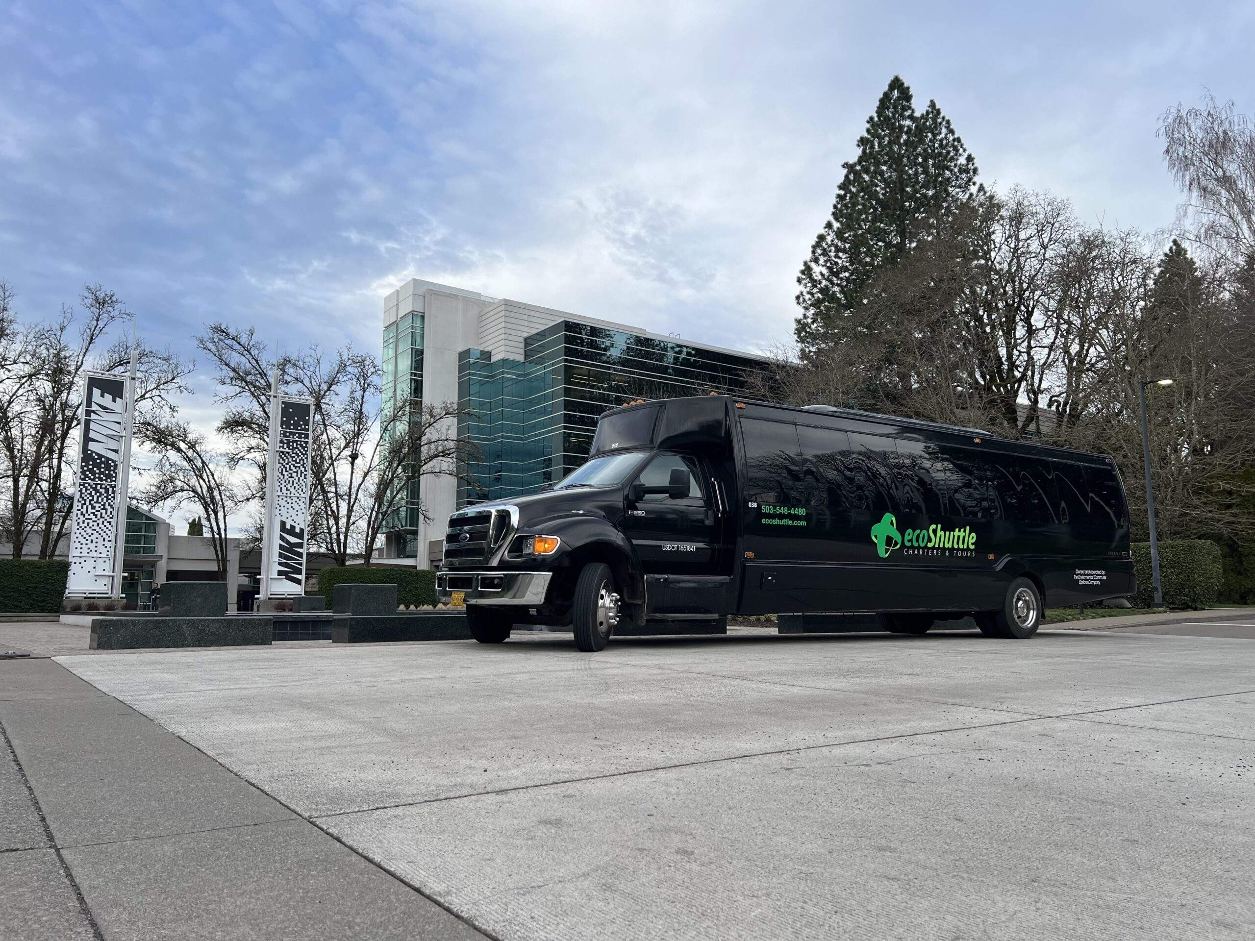 A luxury charter bus picking up for a corporate event