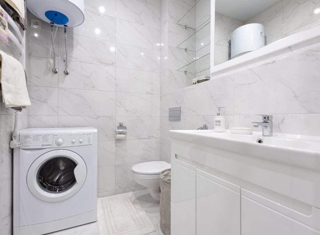 A washing machine below a water heater.