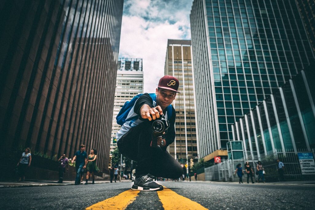 A person standing in the middle of the street with his camera